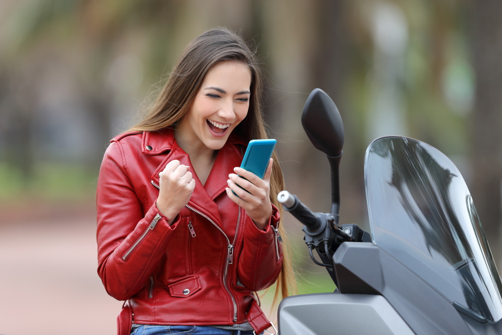 Mujer biker feliz por obtener el mejor seguro de moto