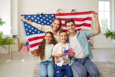 Familia celebrando ajuste de estatus en Estados Unidos con bandera