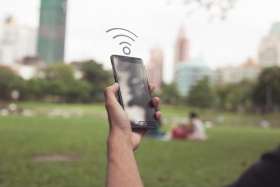 Mano de hombre en un parque sujetando un teléfono celurar para saber cómo encontrar wifi gratis en un parque de Estados Unidos