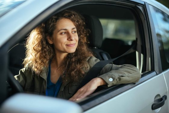 Mujer con su registracion de vehiculo al dia - Cost-U-Less